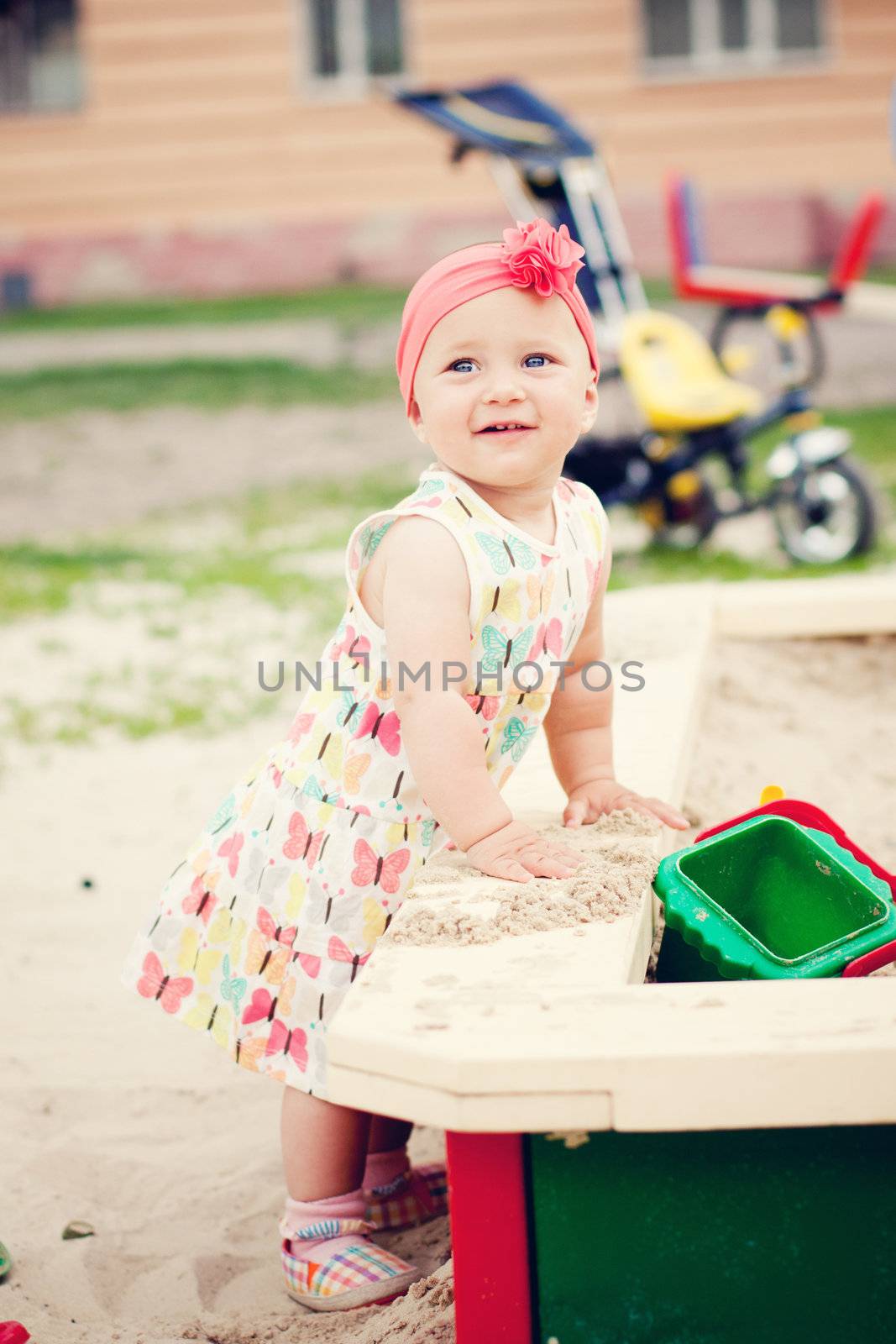Cute baby girl playing with the sand