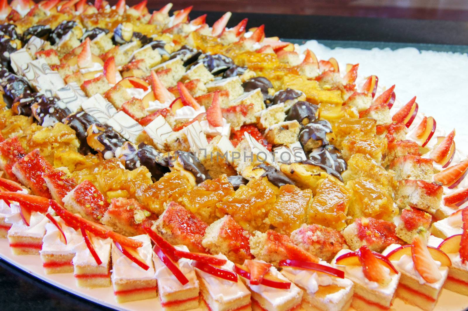 Cakes with tropical fruits at the table              