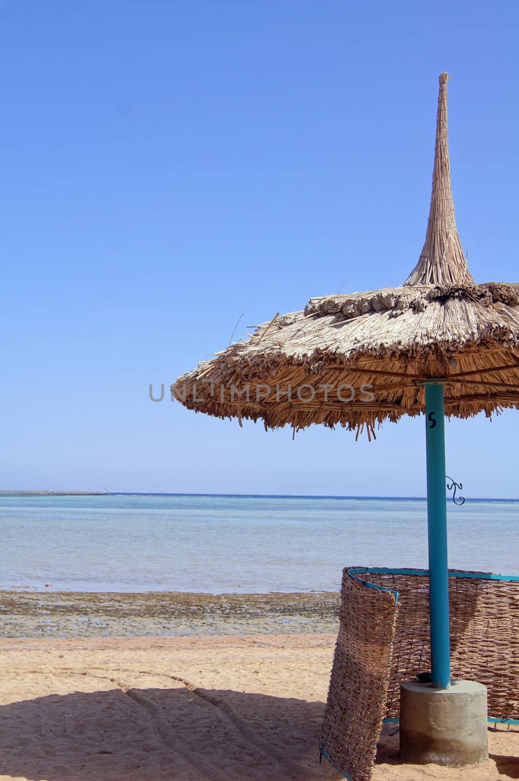 Sun umbrella, sand beach and sea  