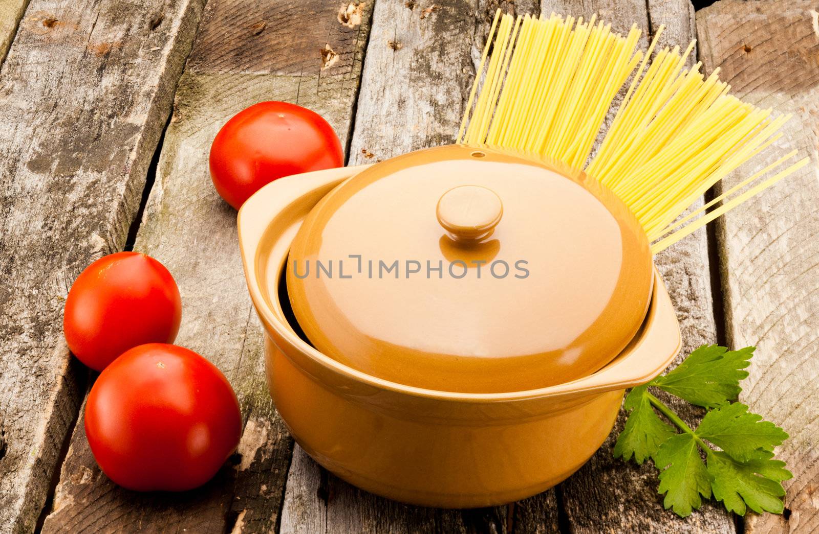 ceramic pan with pasta on old wooden plank