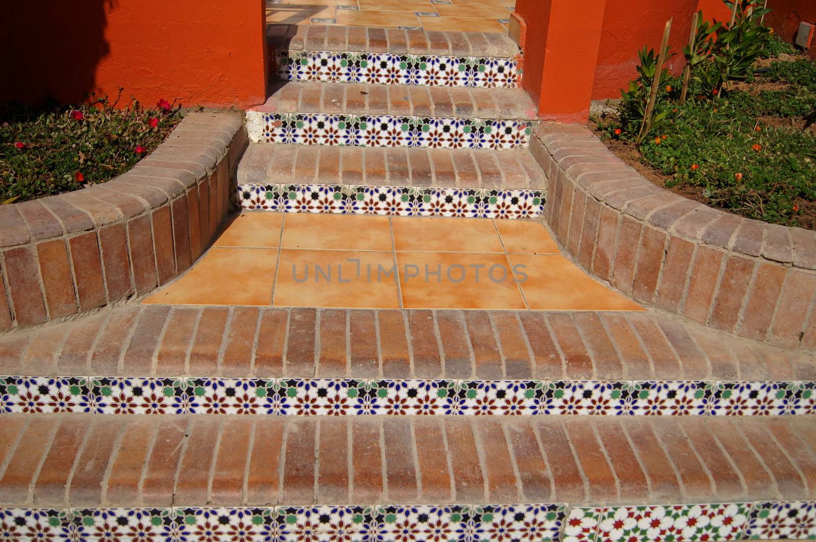 Courtyard of mediterranean villa with ceramic tile walkway and blooming bushes in Egypt           