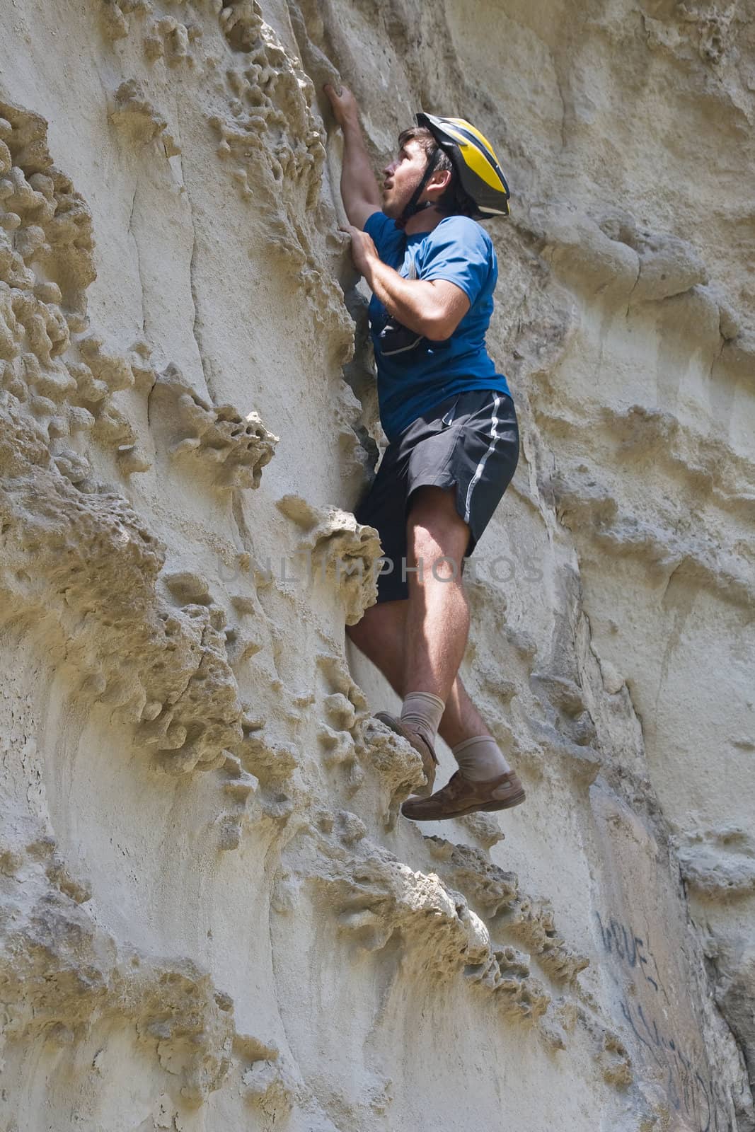 Young sportsman climbing a cliff without belay