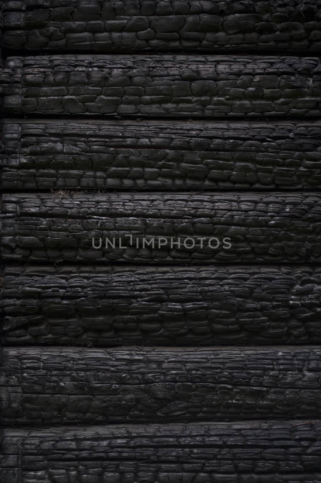 Fragment of  black burnt log wall, useful as background