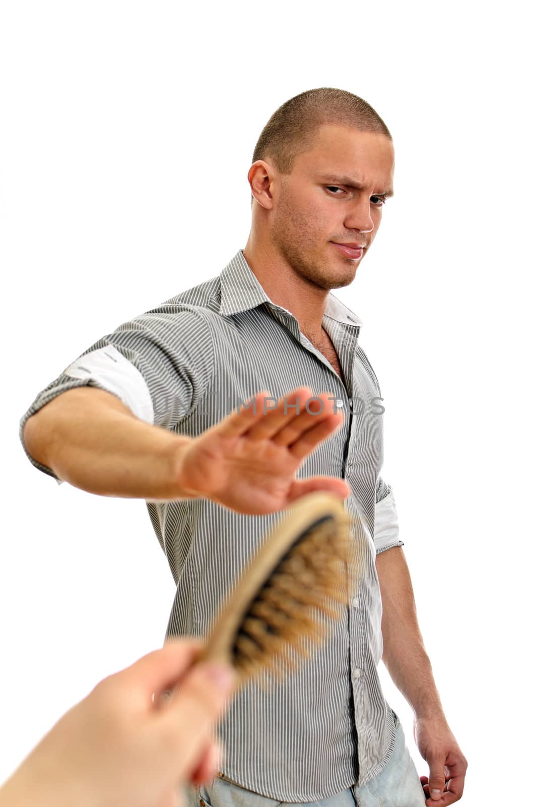Hand offers hair brush to man with short hairstyle. Isolated on white.