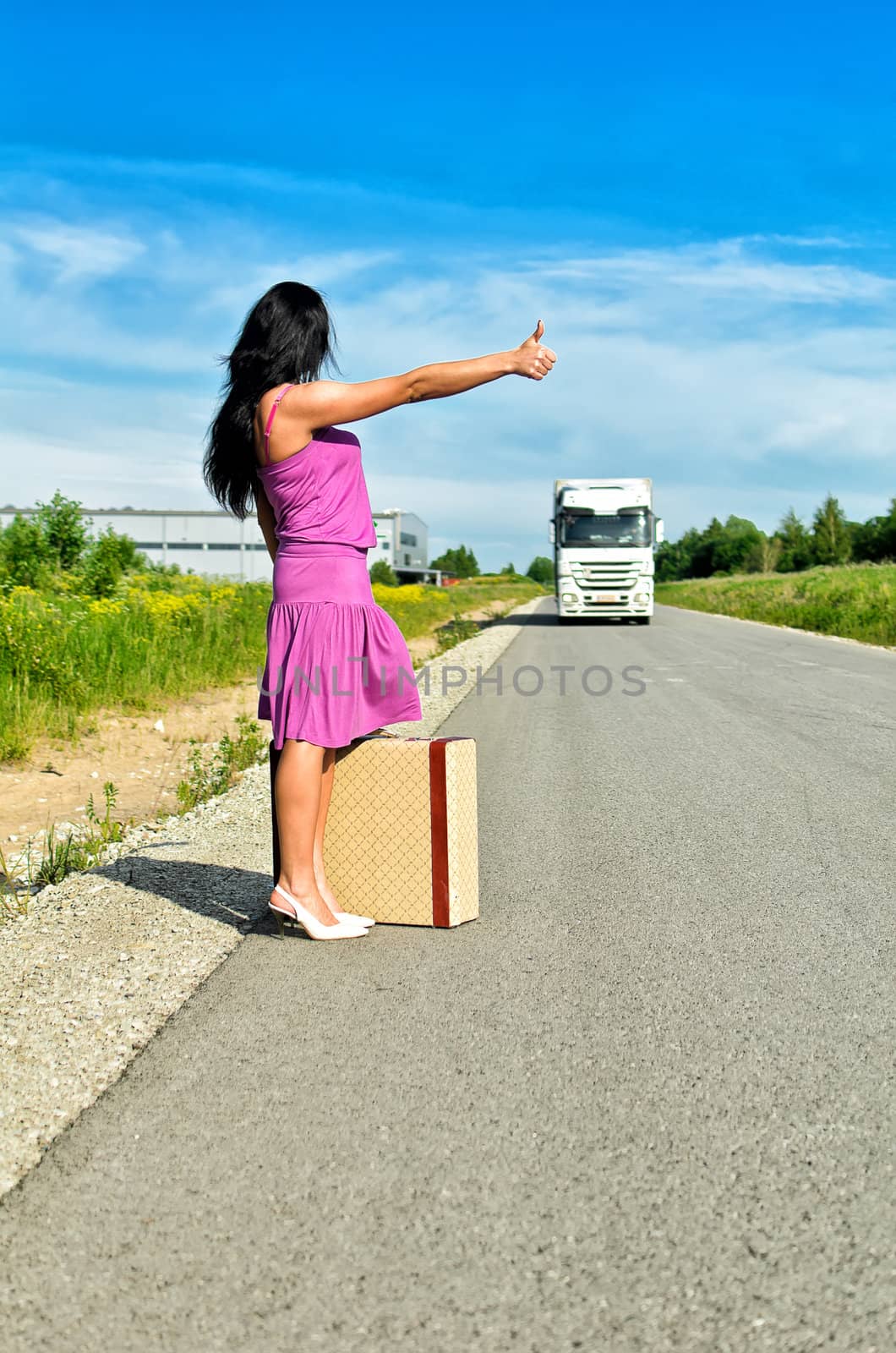Woman with suitcase hitchhiking a car