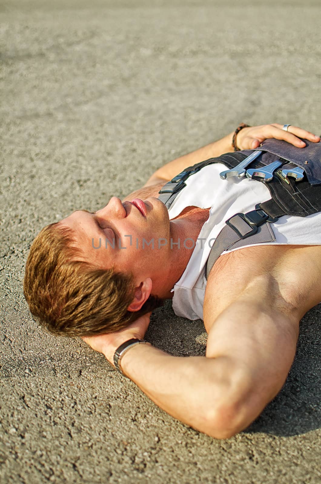 Tired mechanic resting on the road