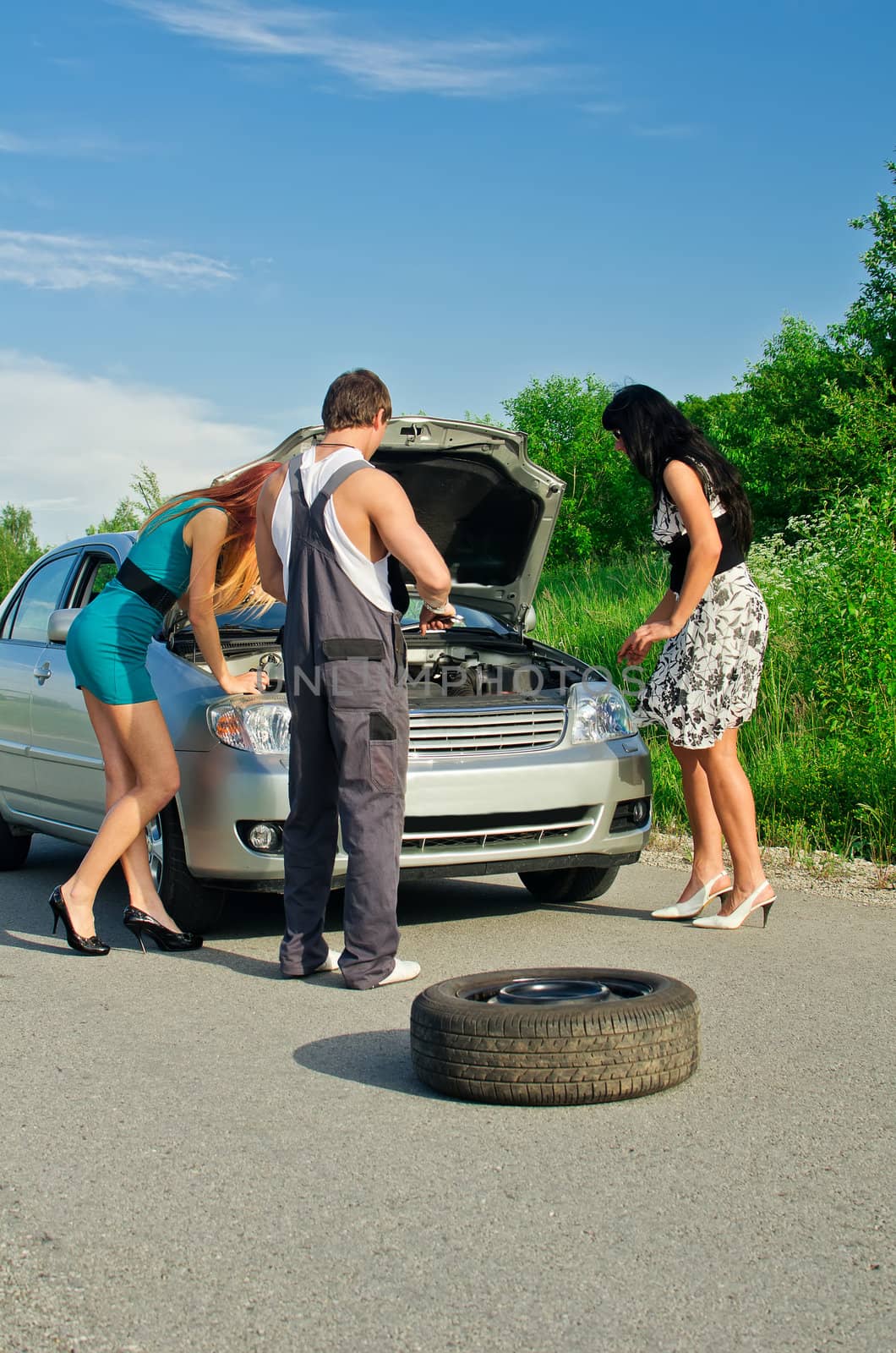 Mechanic and two girls near the broken car on a road by dmitrimaruta