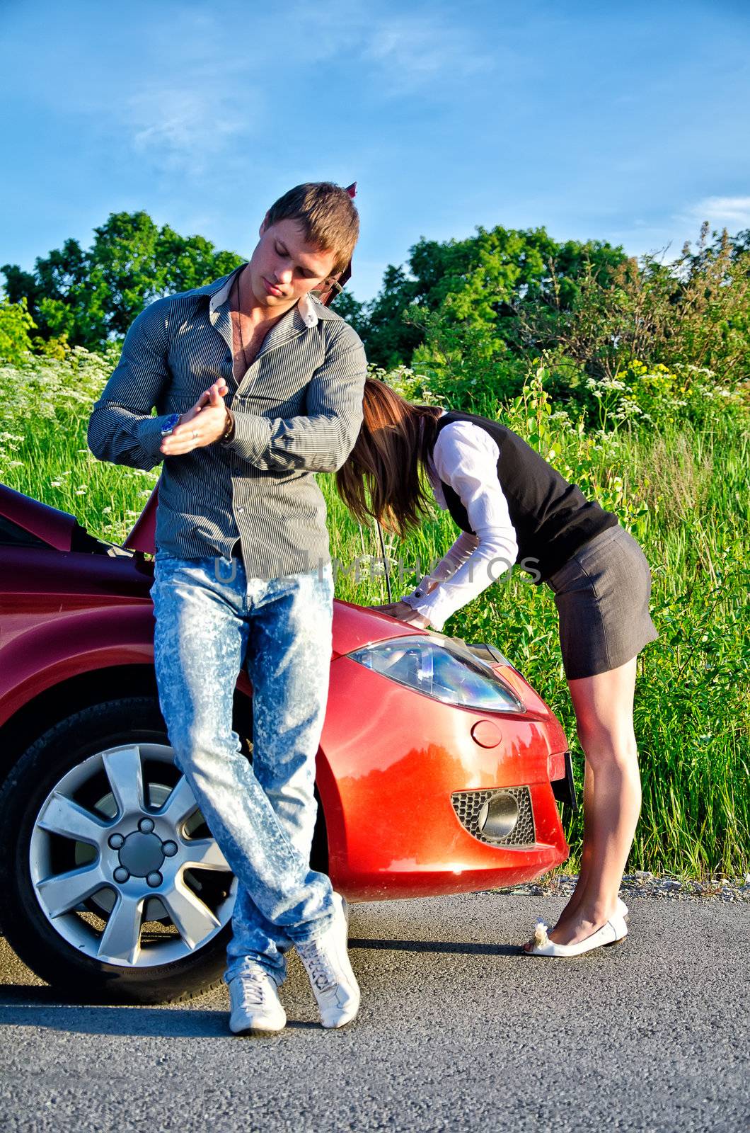 Man is waiting his girlfriend repairs a broken car