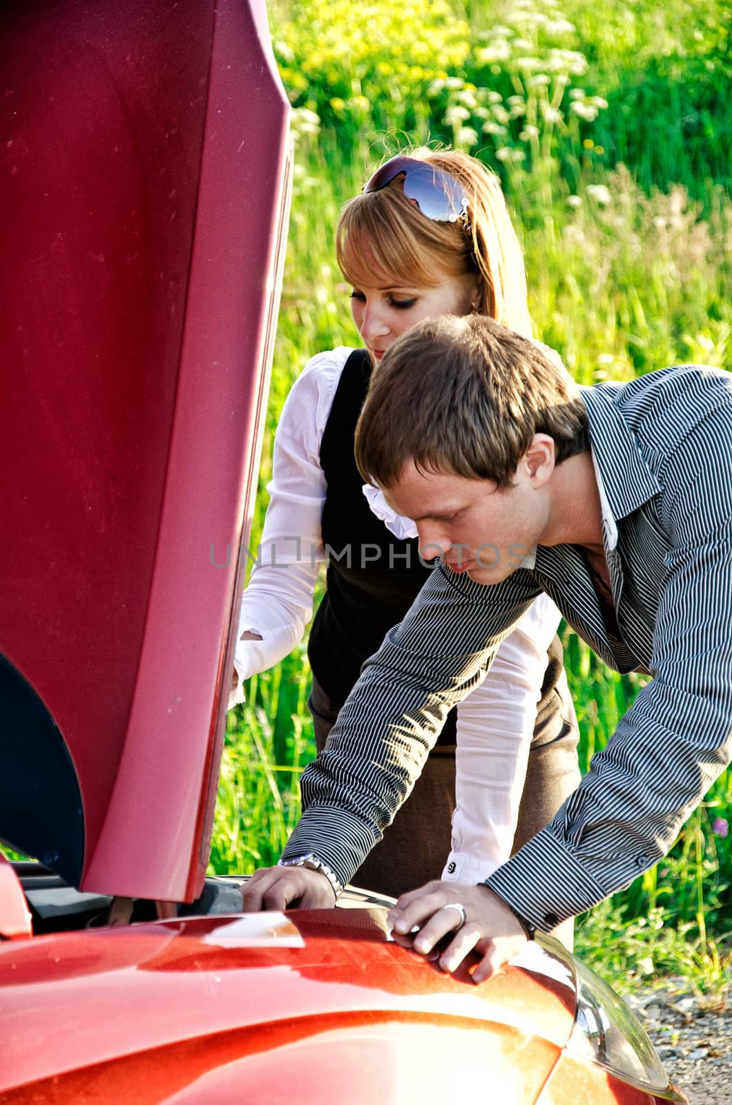 Man and woman are looking at the car engine