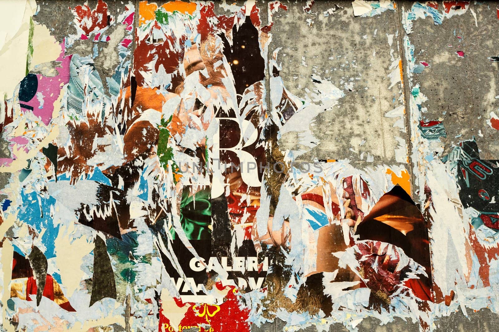 grunge background on billboard with old torn posters 