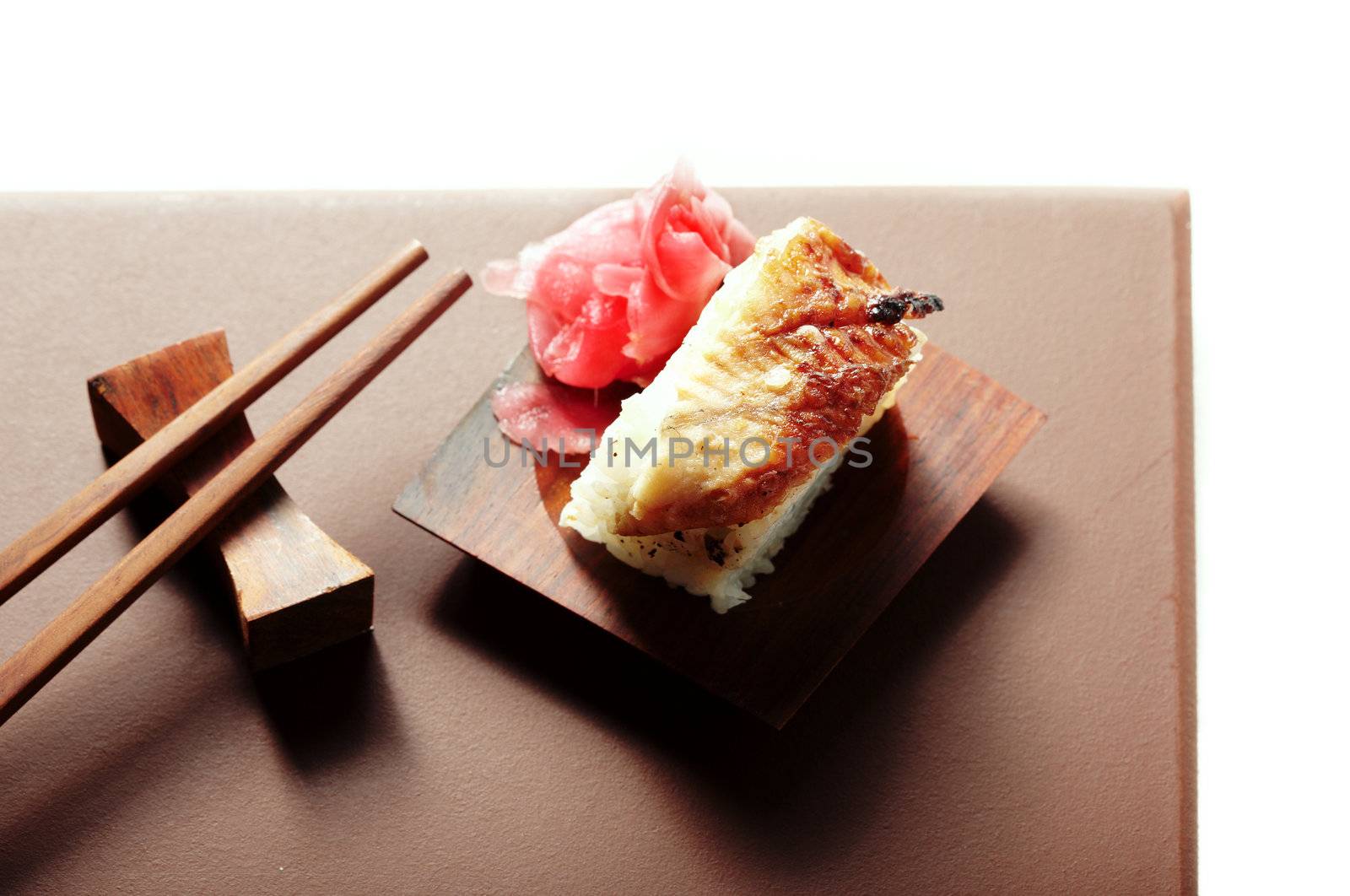 Top-view close-up horizontal photo of the sushi with ginger on the table and chopsticks. Shallow depth of field and vivid colors