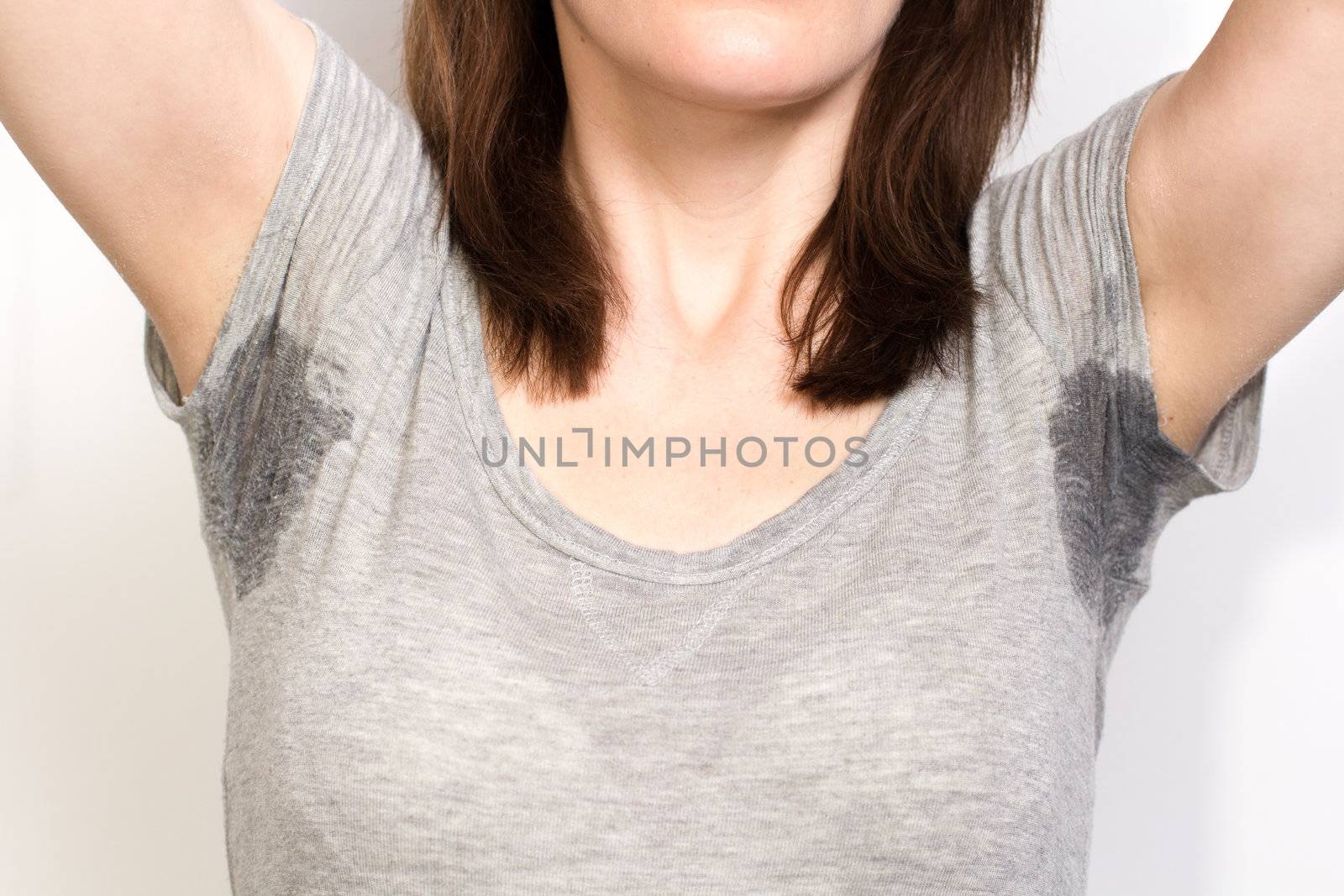 Woman sweating very badly under armpit and holding nose