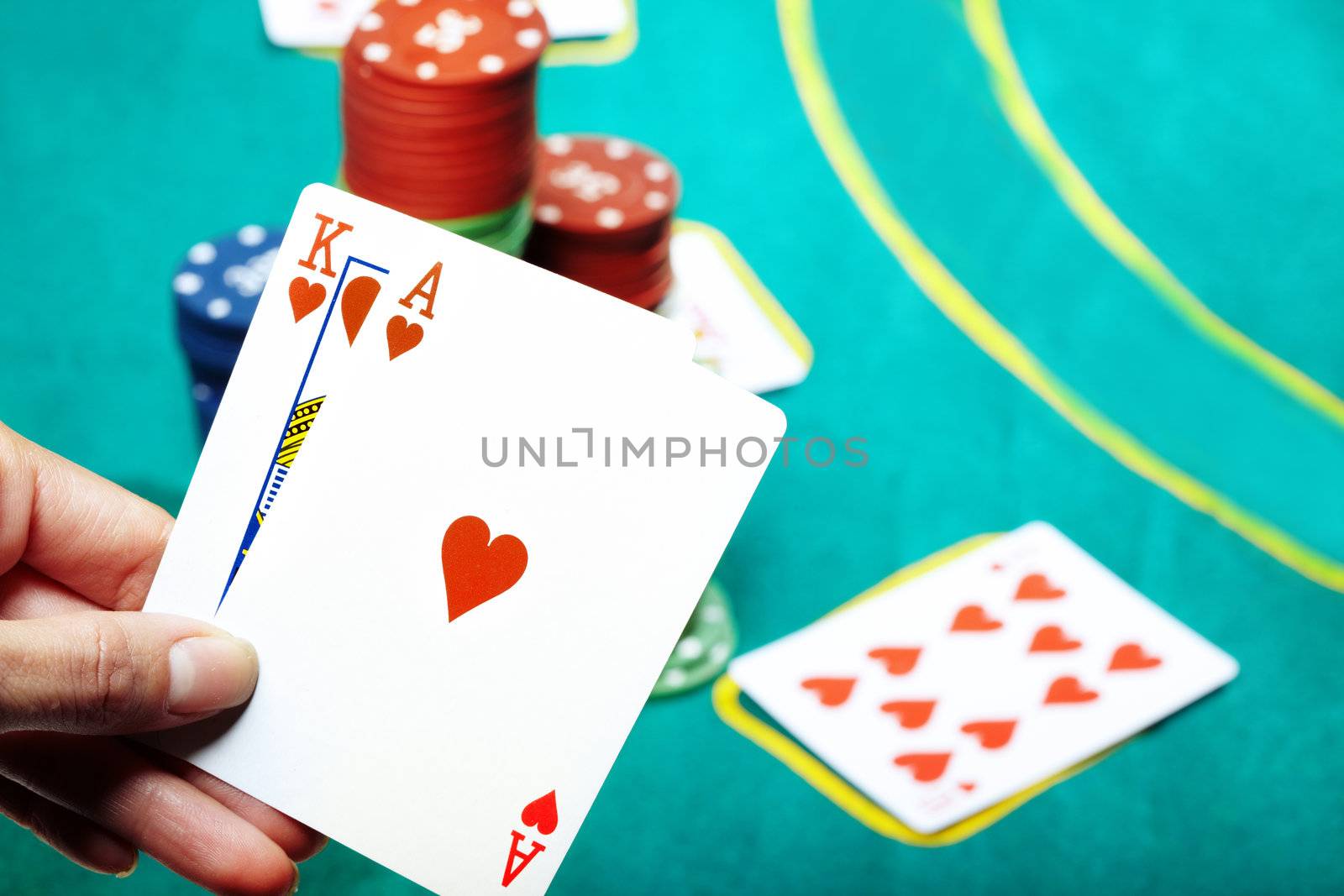 Human hand holding two cards in casino. Poker chips on a background