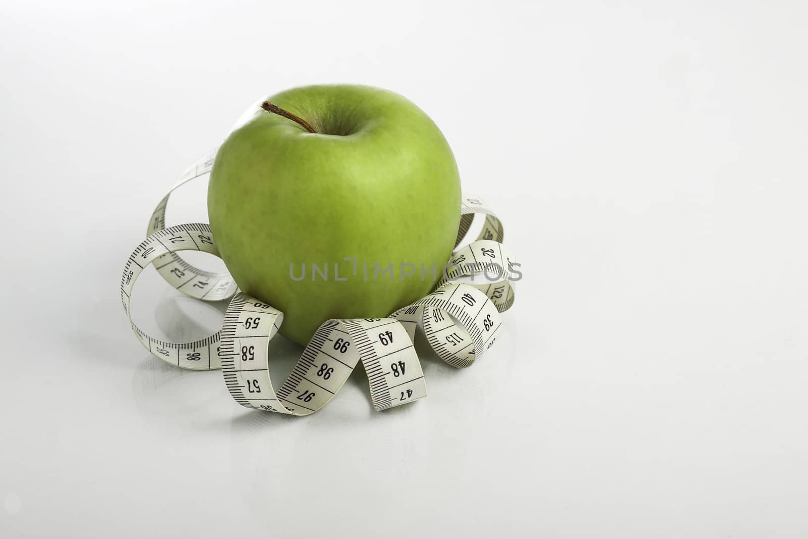 green apple wrapped with measure tape