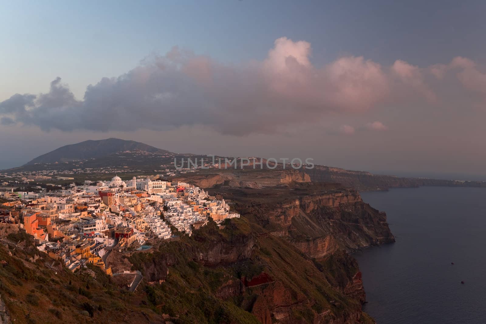 Thira and Santorini island view in beams of sunset
