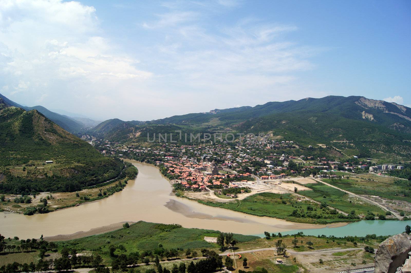 River junction on mountains and sky background