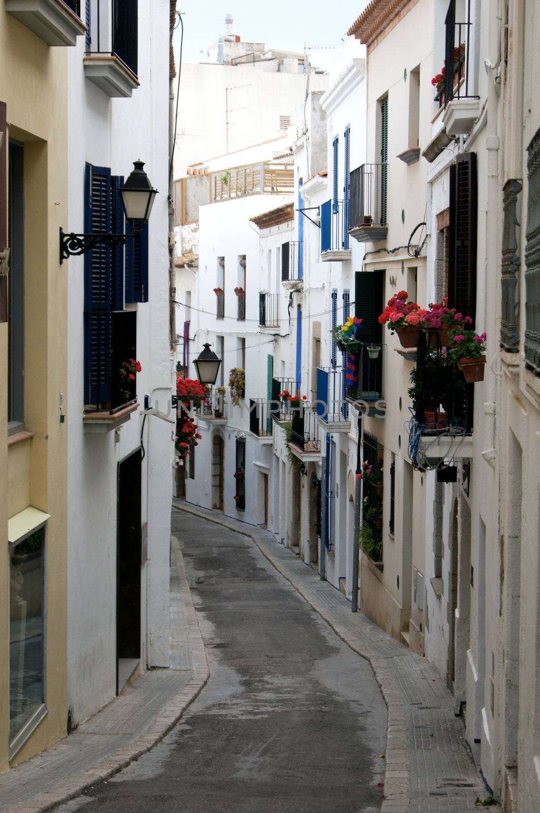 Narrow medieval street in Old Sigest town, historical resort-city close to Barcelona city, Spain by Elet