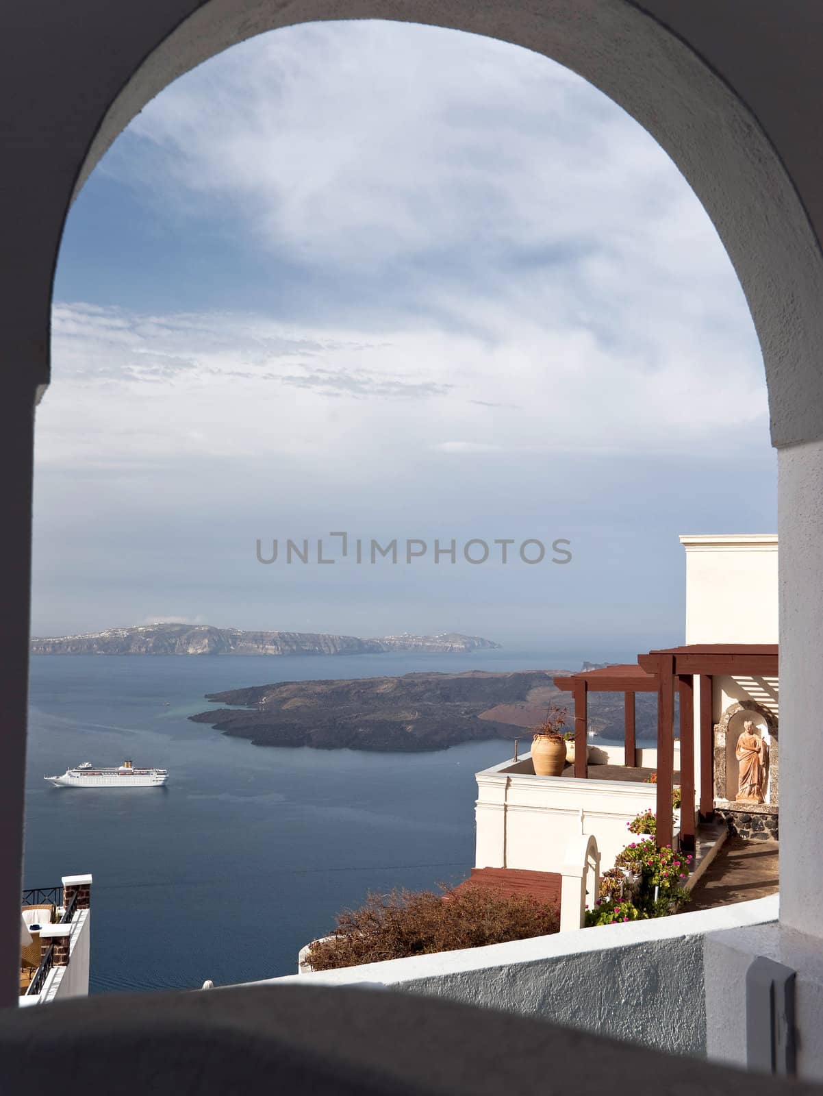 Caldera view in Santorini island with buildings and ship through the balcony arc
