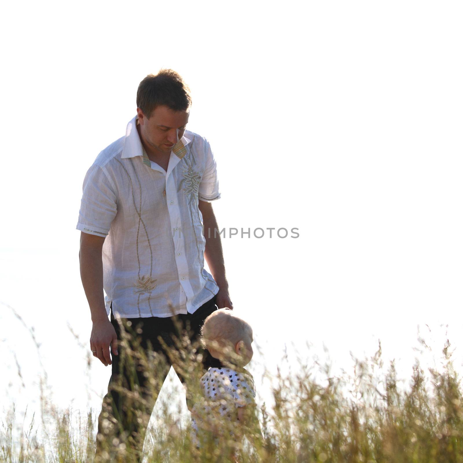 father and son walking on grass