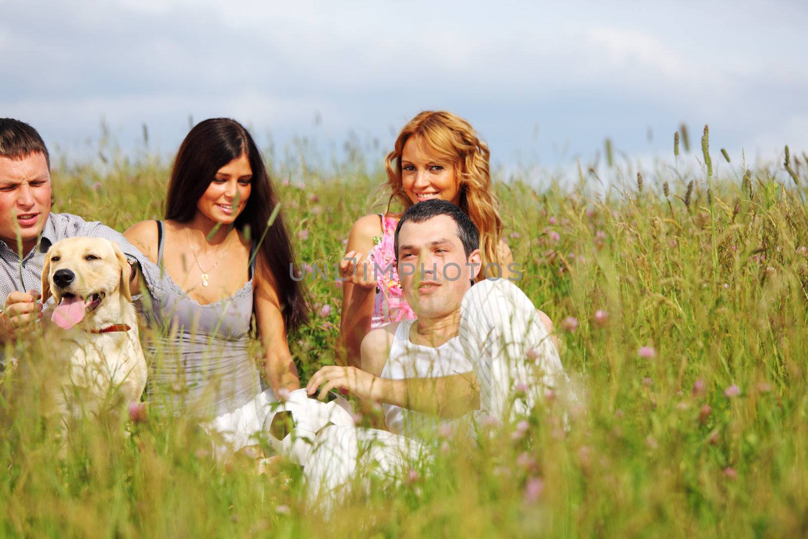 friends and dog in green grass field