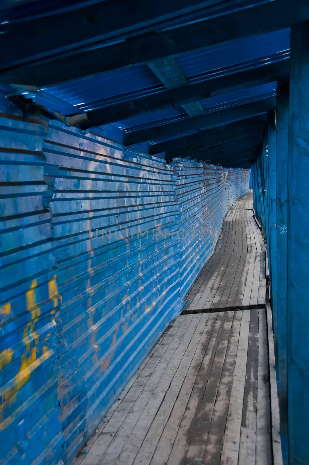Long, wooden, metal and blue tunnel in ghetto