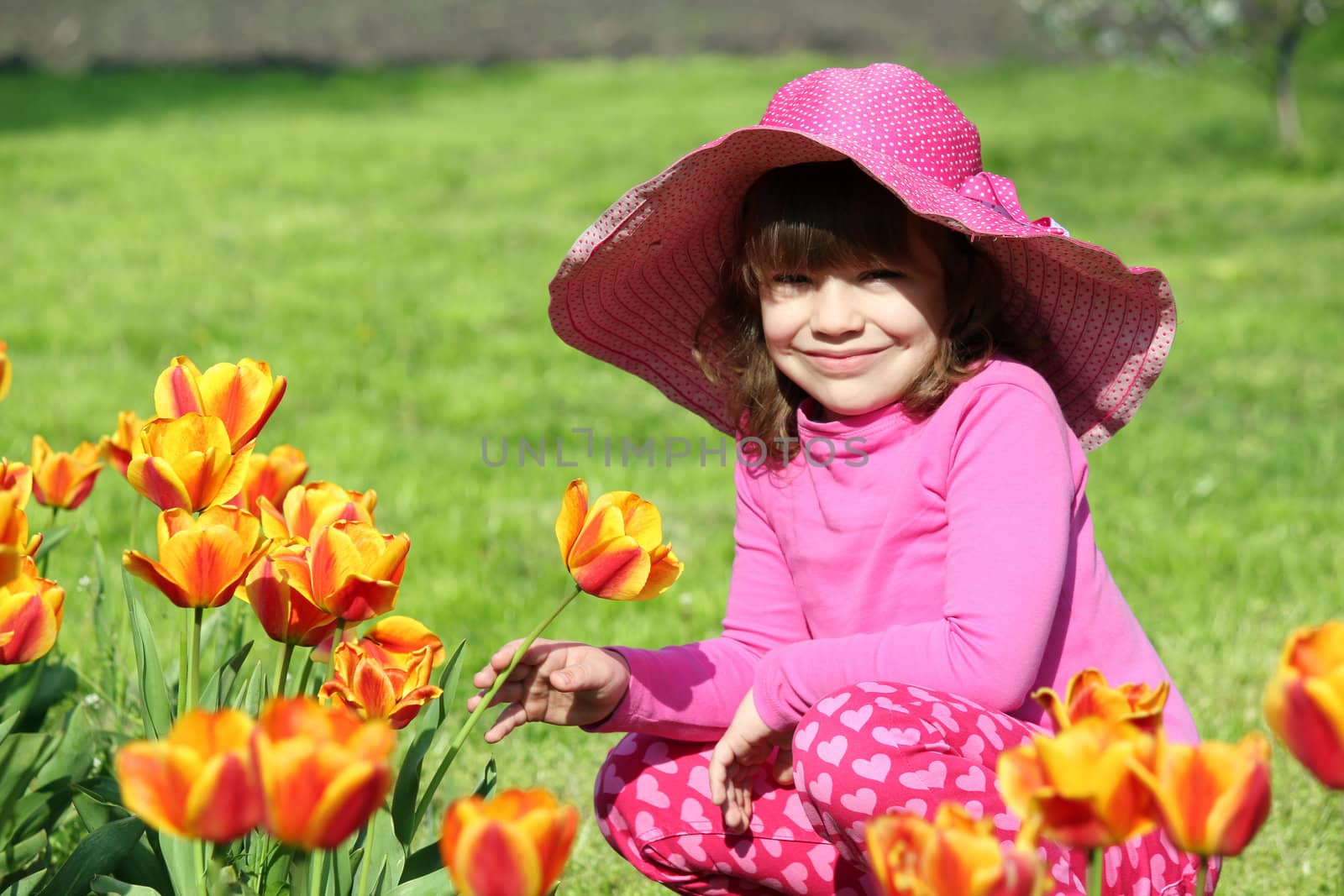 little girl with hat and tulip flowers by goce