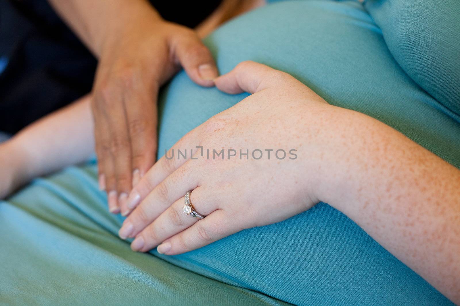 Mixed ethicity couple make a heart on her pregnant belly