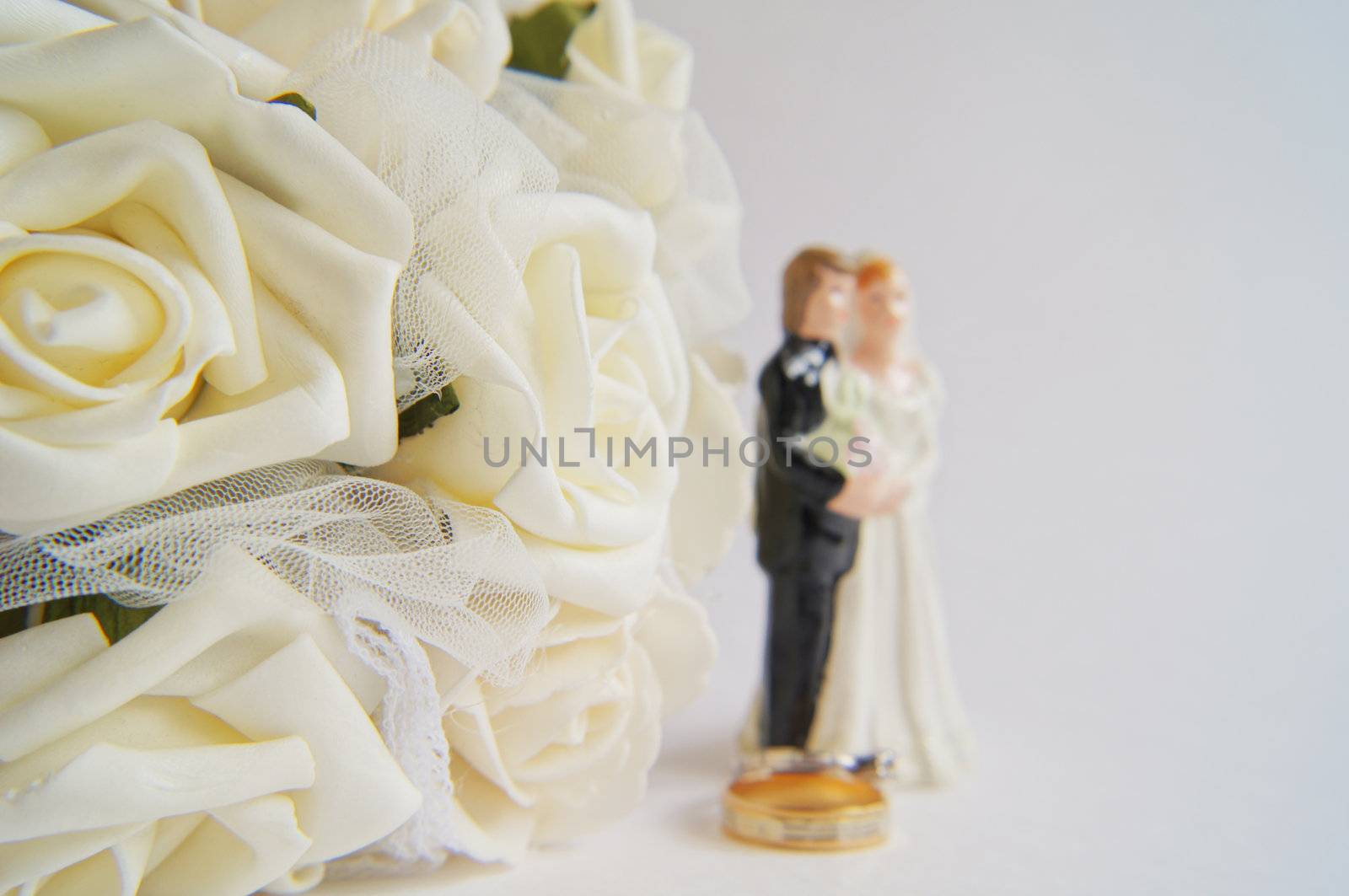 Wedding decoration - white roses bouquet, rings, bride and groom