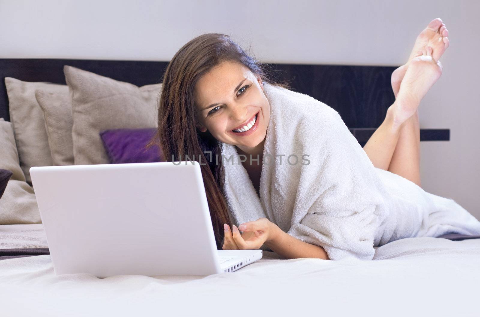 happy lady on the bed with laptop by ssuaphoto