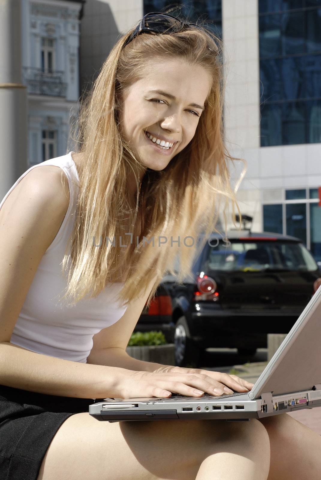 happy student with laptop computer near the modern building