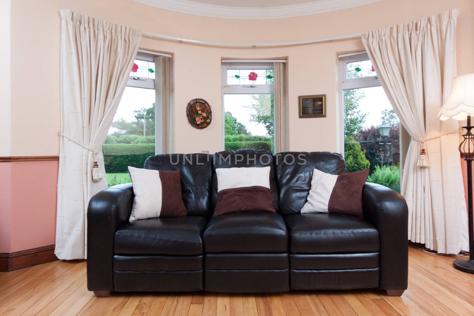 Photo of a black couch with a view to the garden.