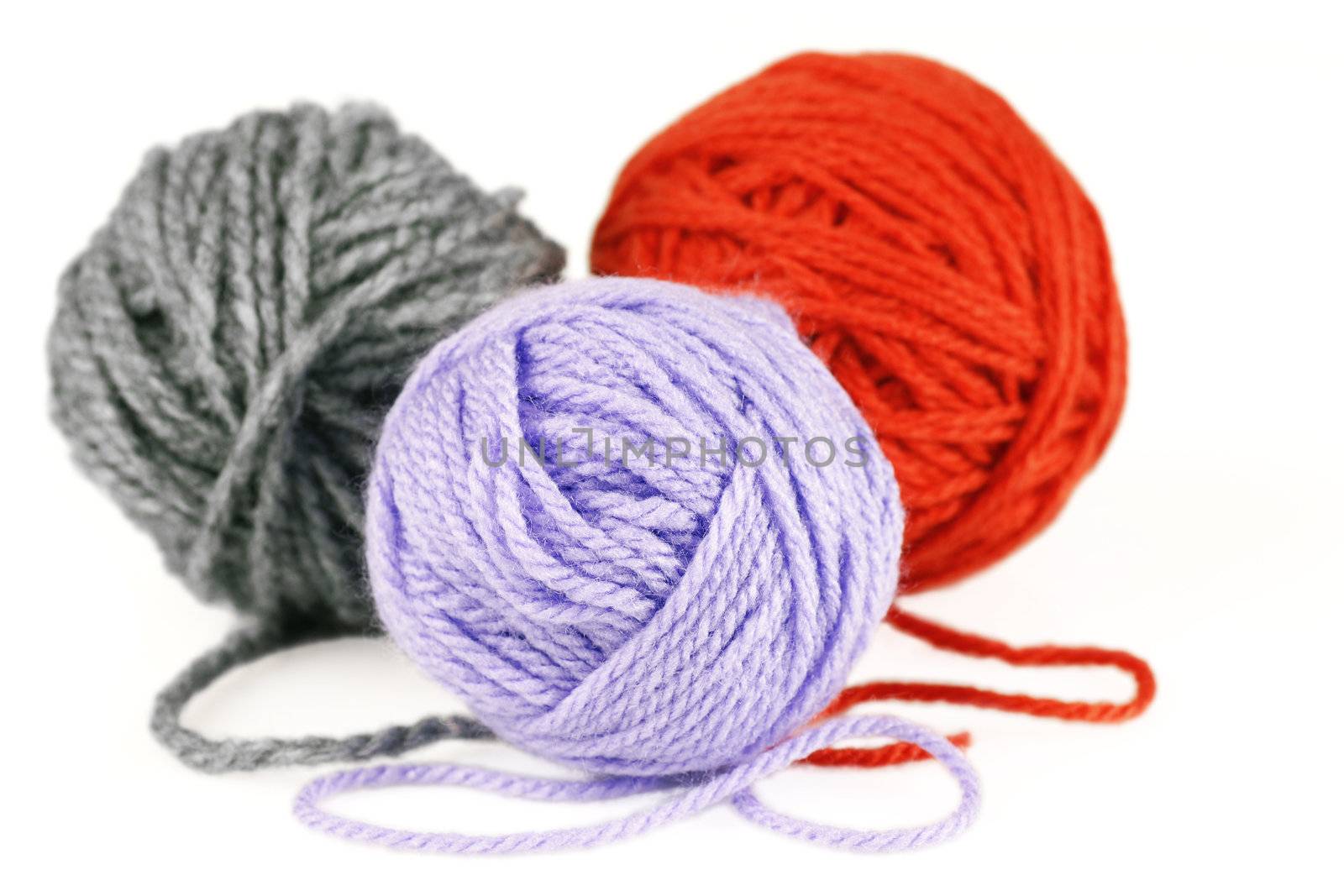 Macro shot of balls of puple,orange and grey wool or yarn, great colorful craft background.