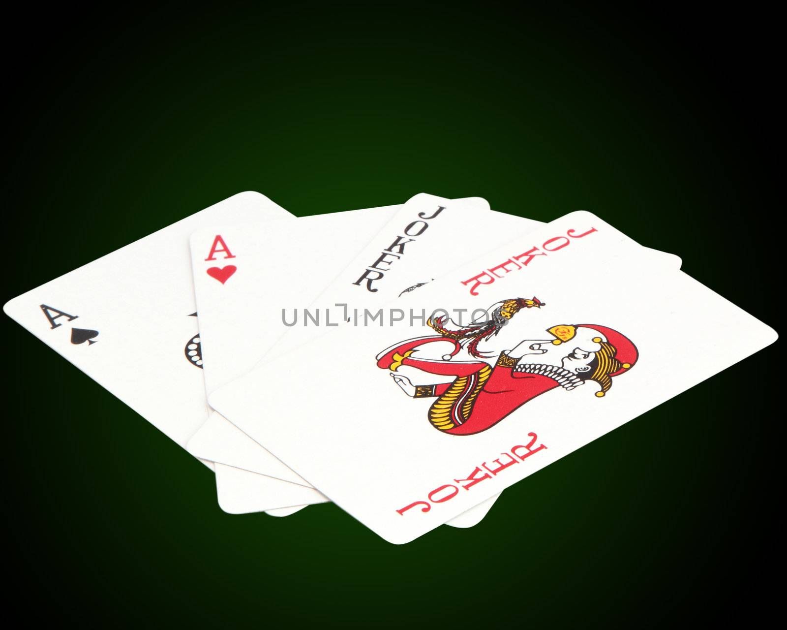 Playing cards. ace and a joker on a green background