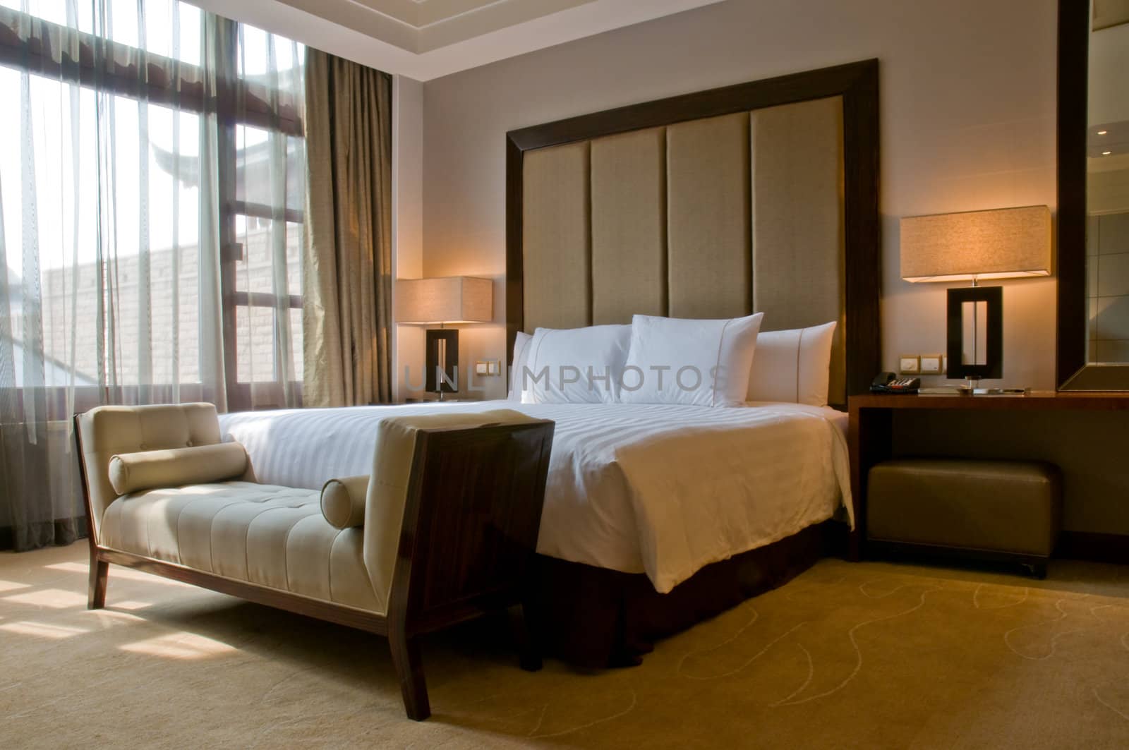 Bedroom of a elegant 5 star hotel suite room at a sunny day