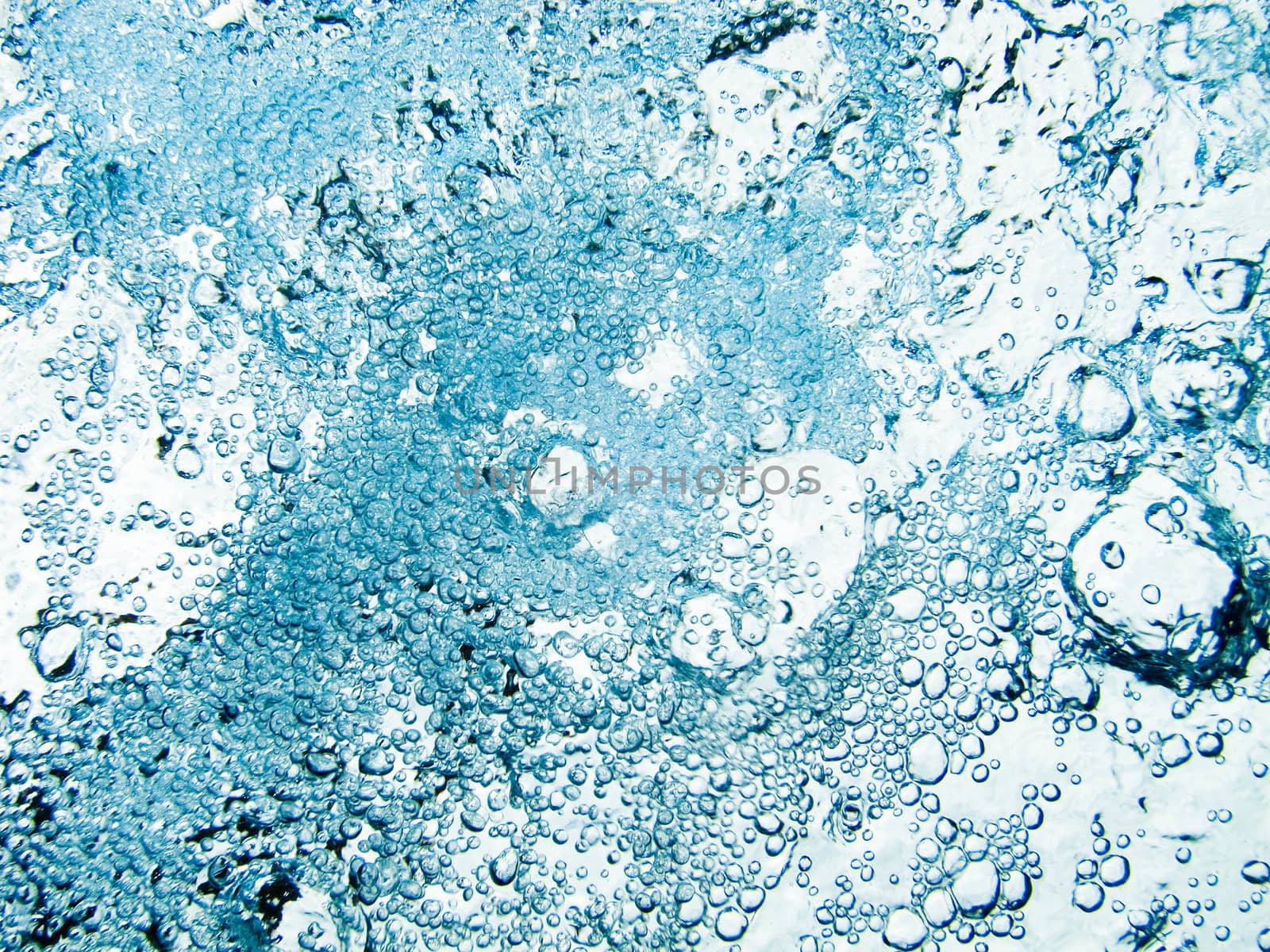 Blue white water bubbles in a pool which lock like boiling water in a cooking pot 