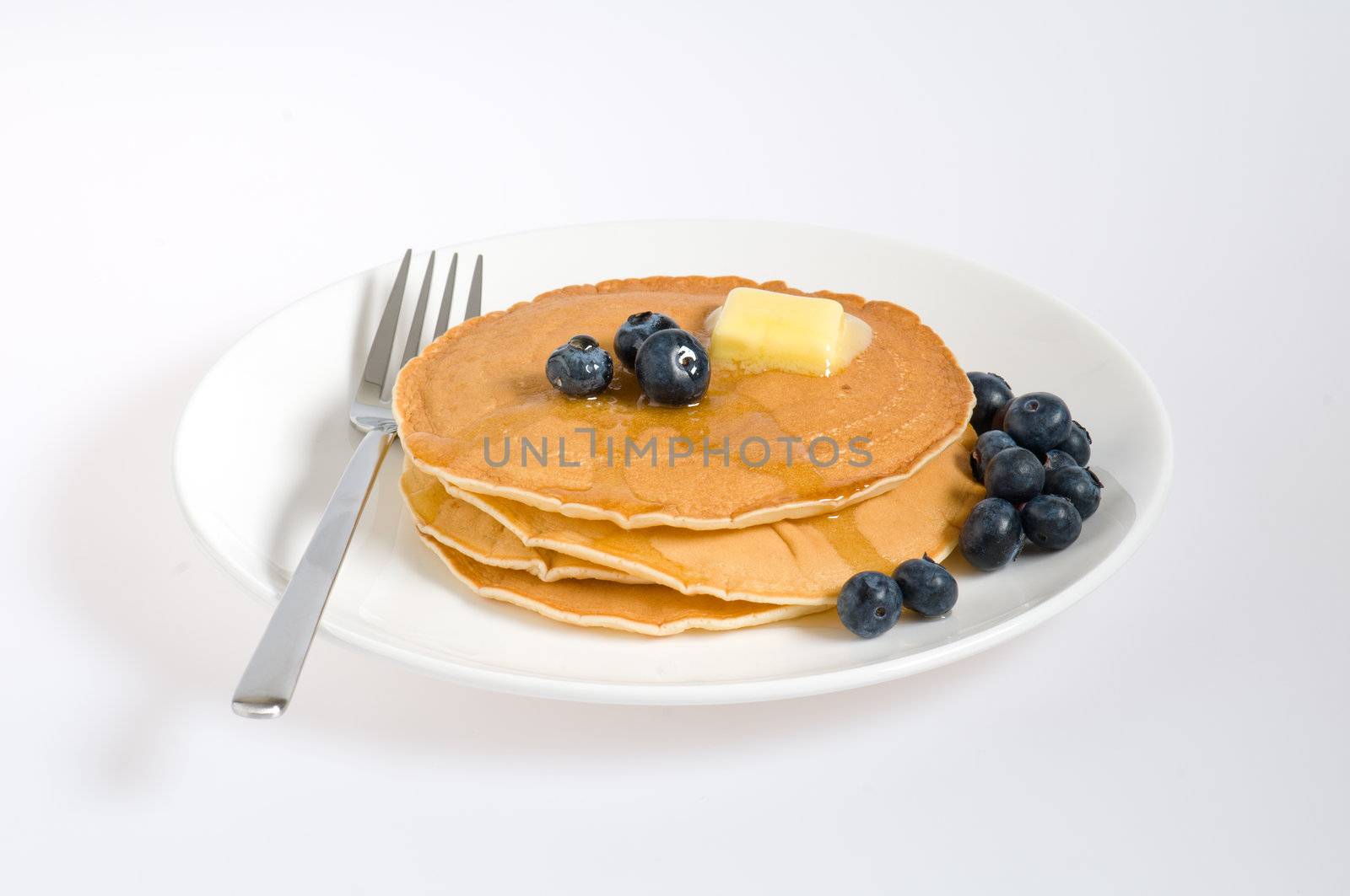 blueberry pancakes on a plate with fork by 3523Studio