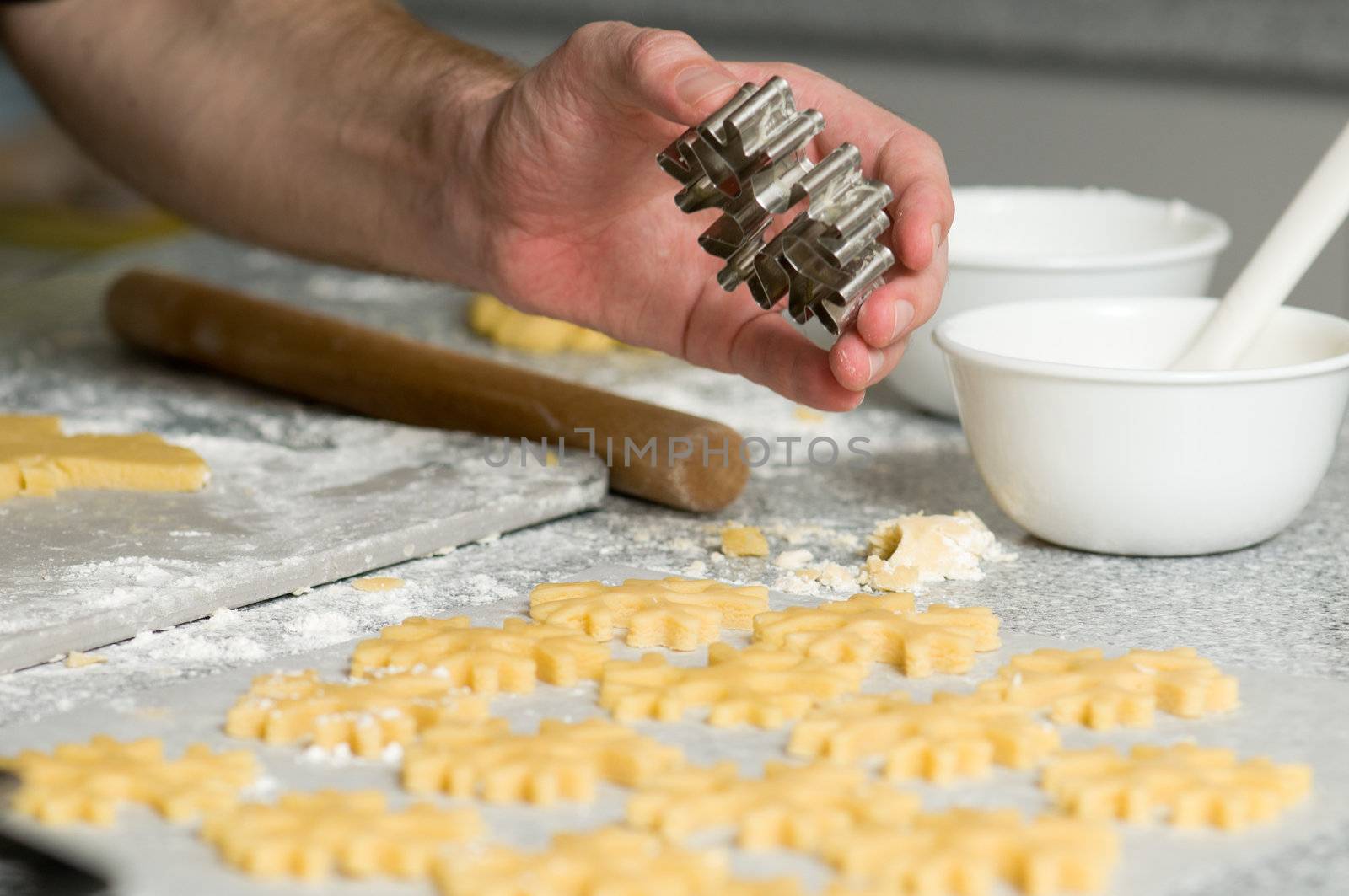 Placing star shape cookies after cutting on backing paper
