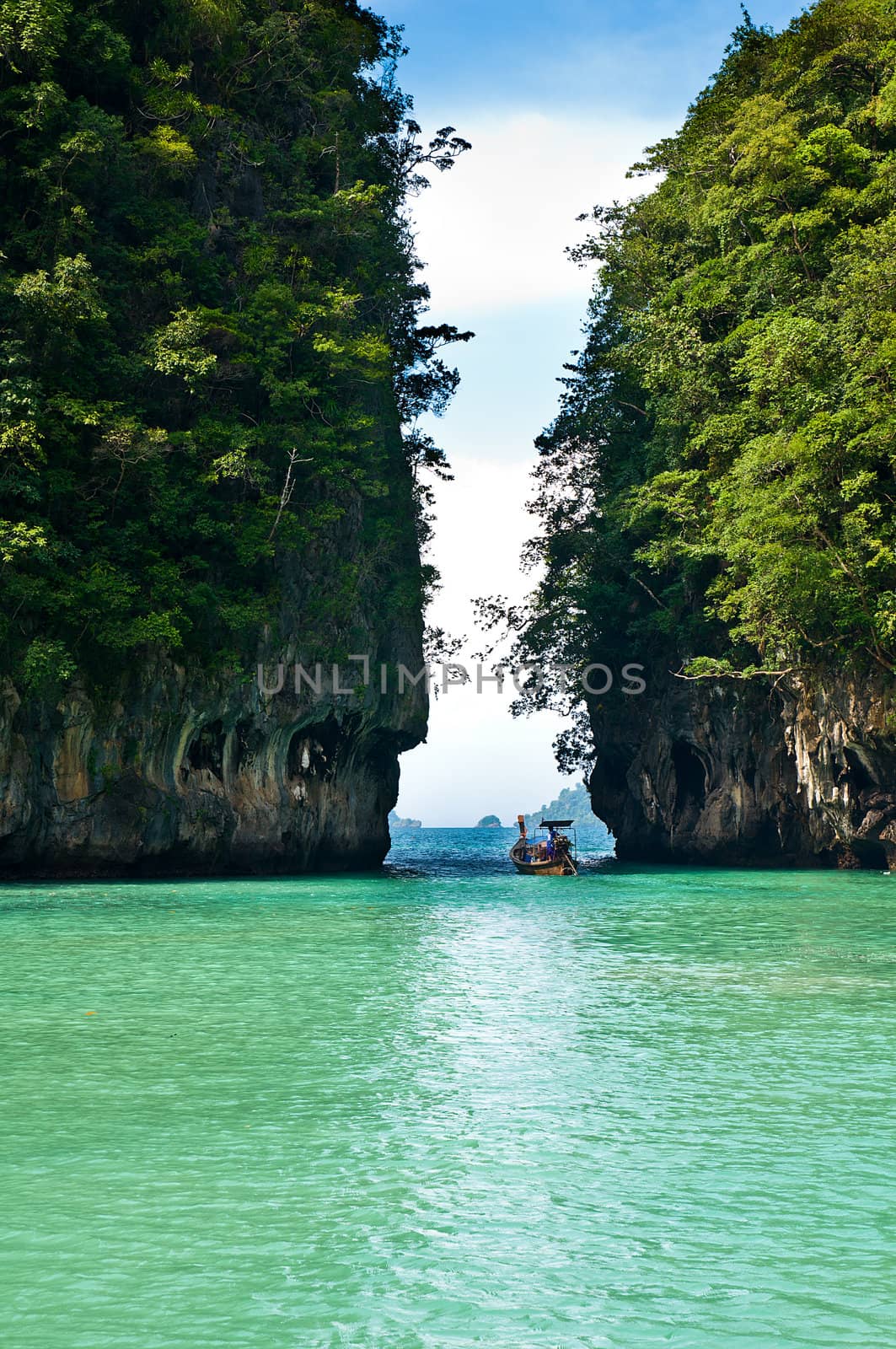 Turquoise lagoon in Thailand with a boat in the background