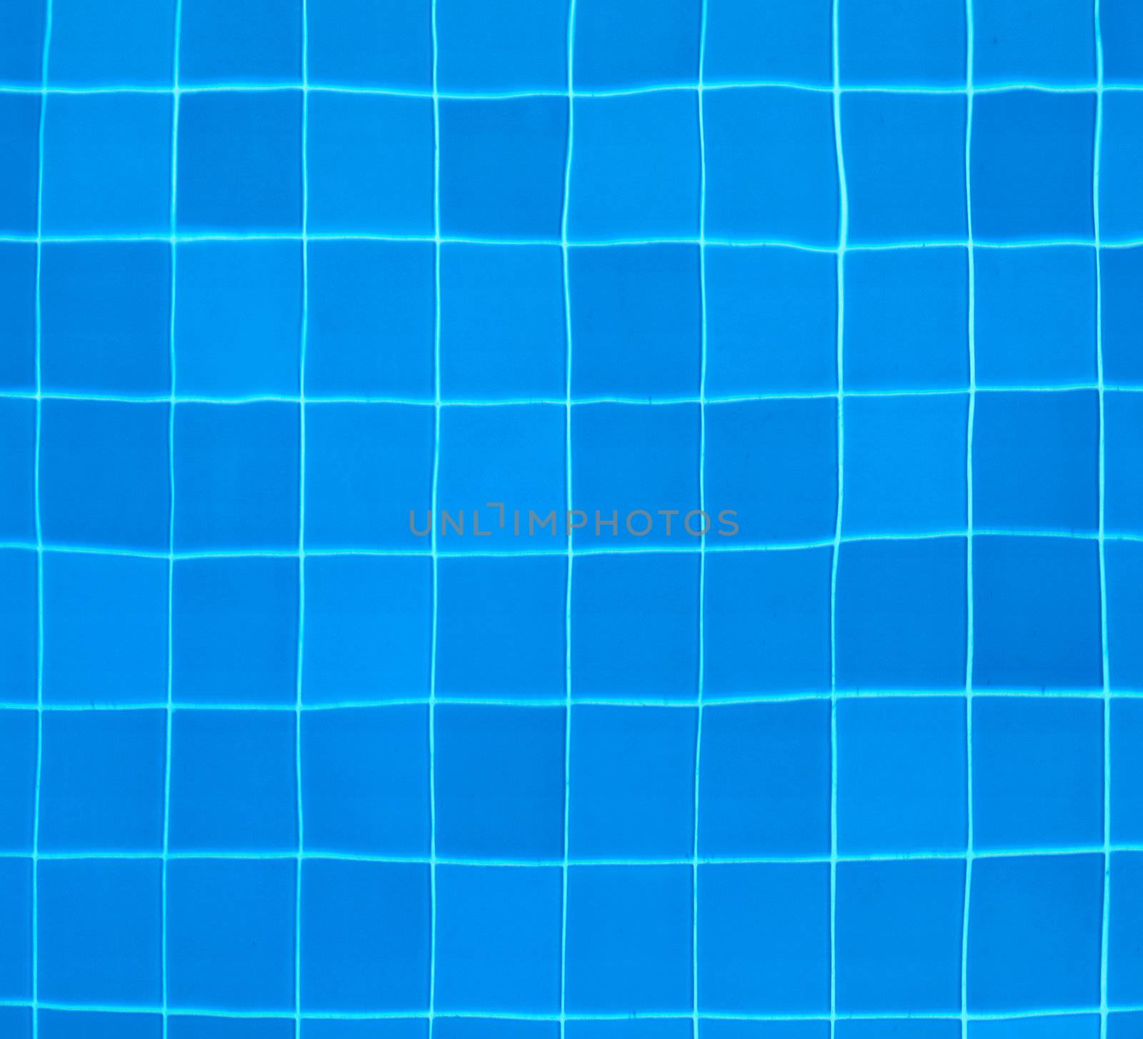 Blue tiles at the bottom of a swimming pool - abstract background