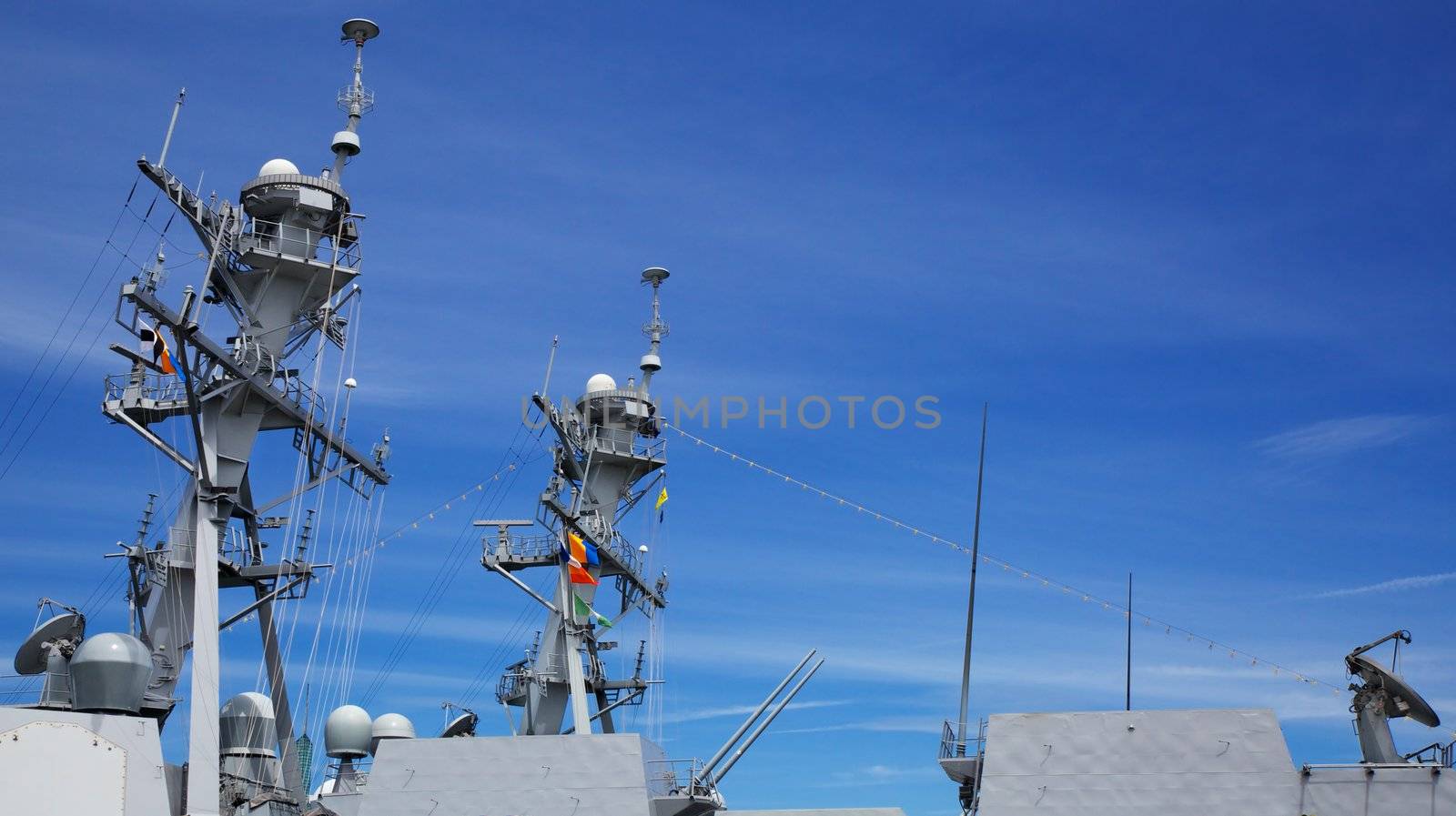 Upper Profile of part of the deck of a Navy Cutter with radar and guns against blue sky