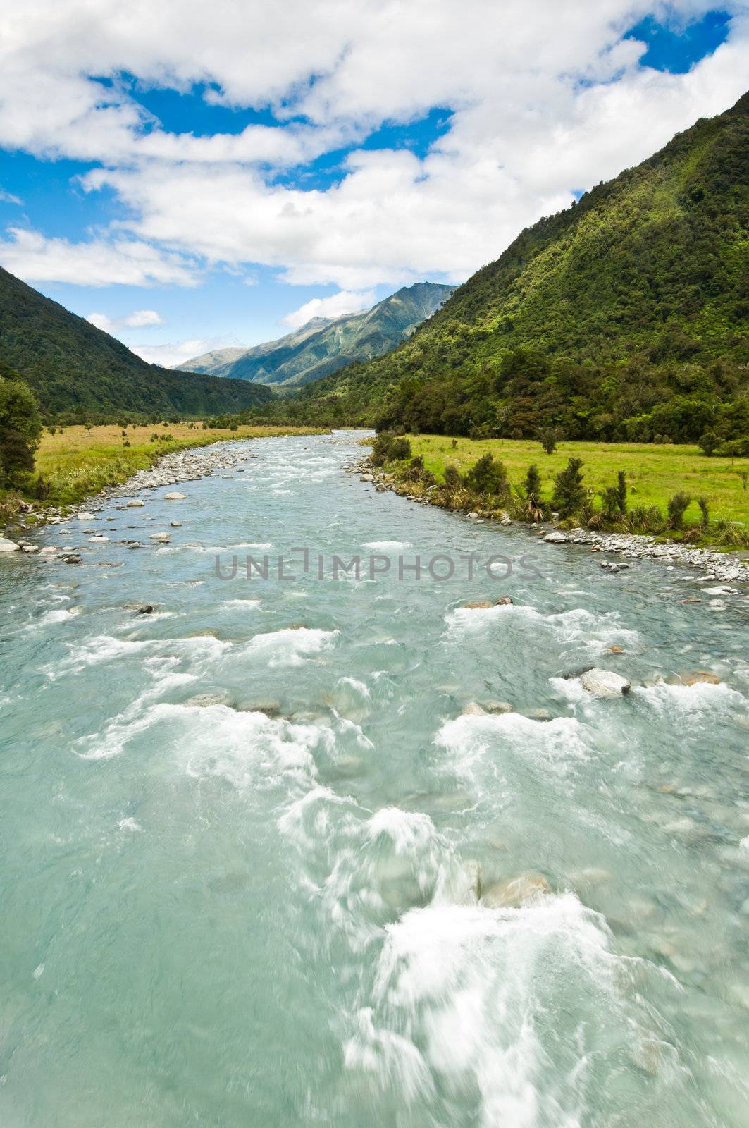 river flowing through a valley with mountain massive in the back ground