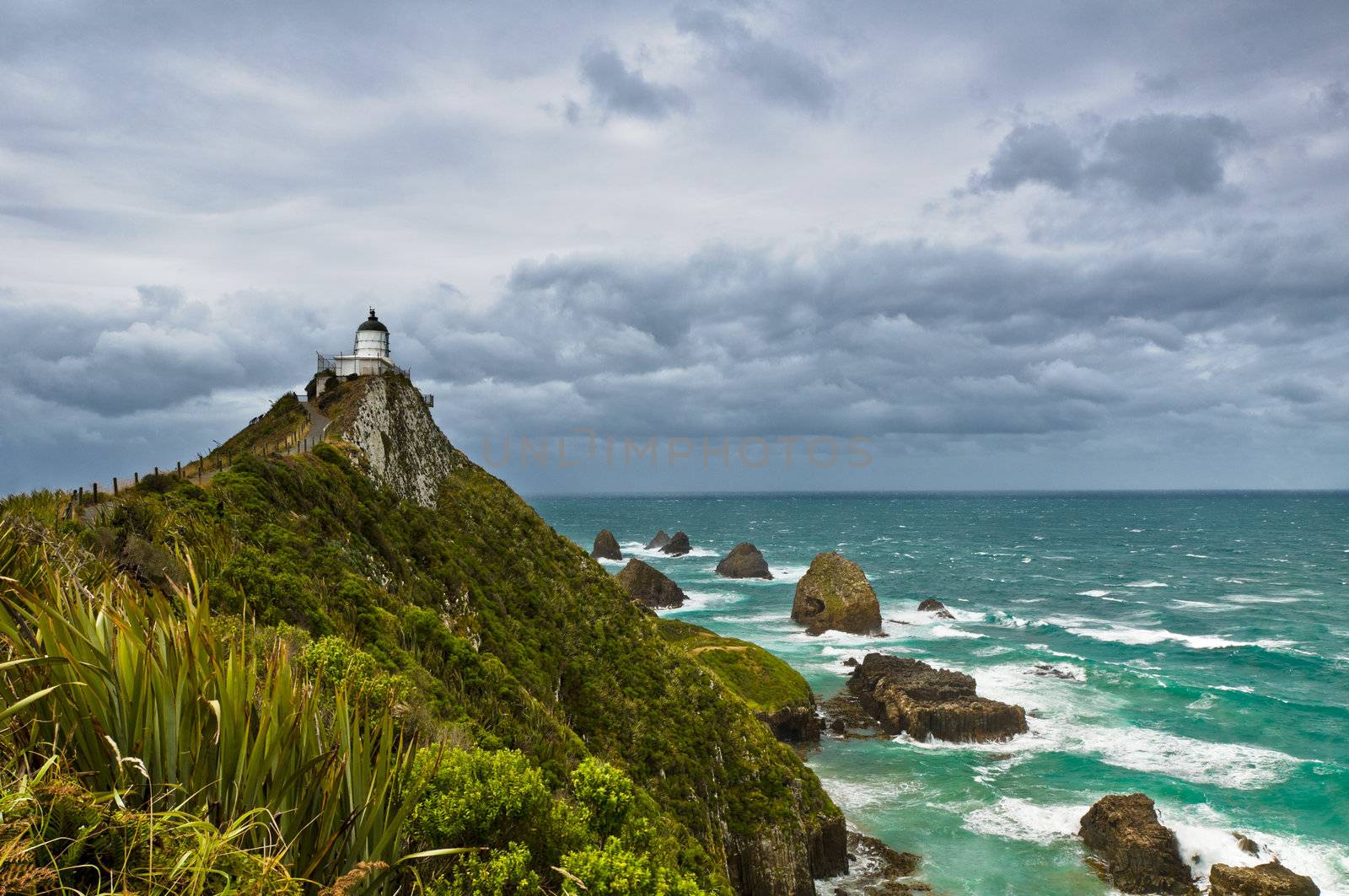 Nugget Point Light House an dark clouds in the sky, Catlins, New Zealand