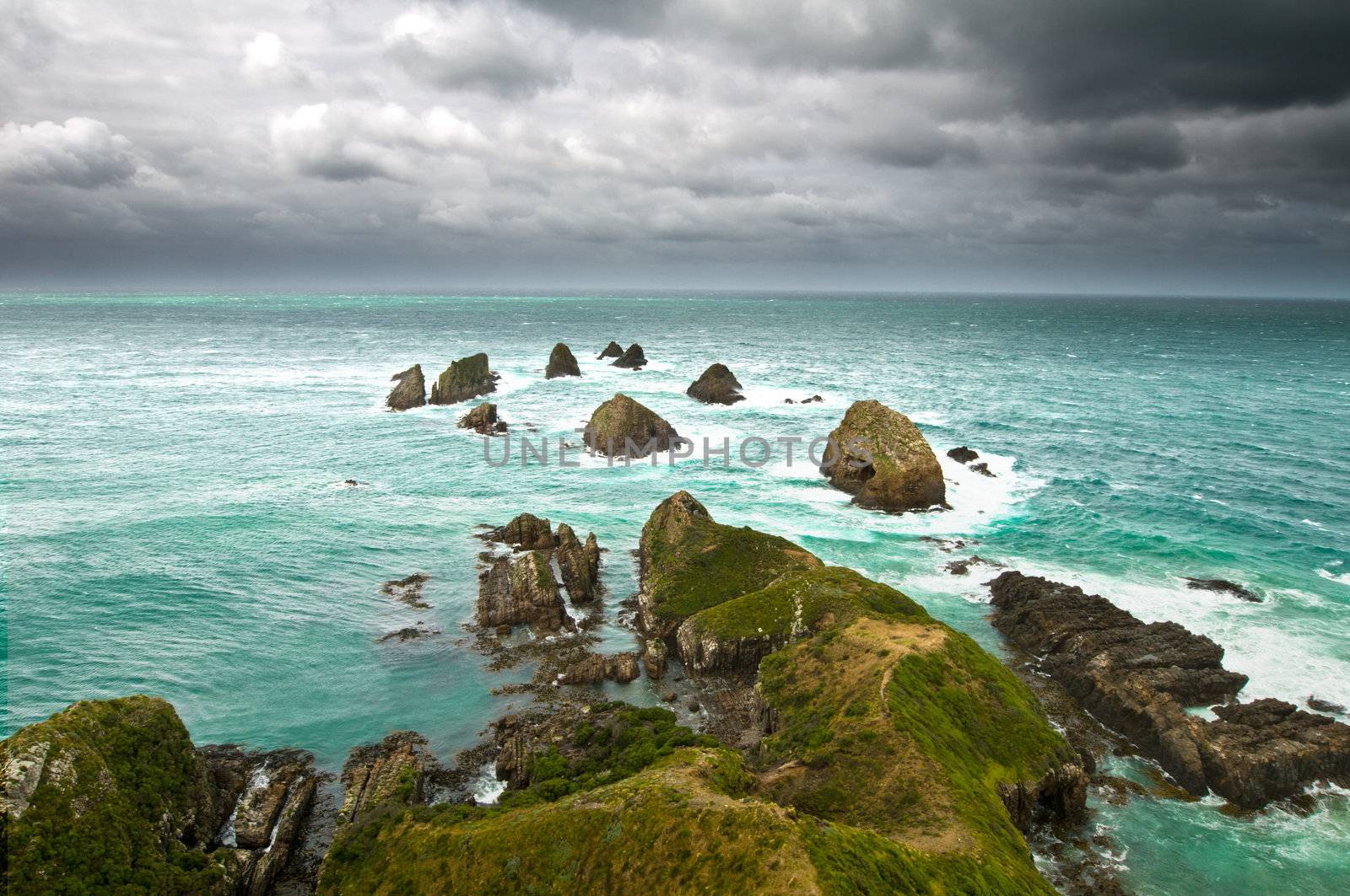 Cliffs under thunder clouds and turquoise ocean by 3523Studio