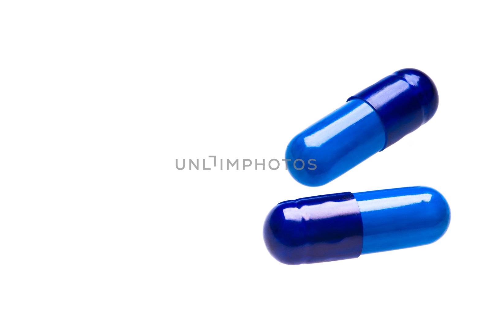 Two blue capsules over white