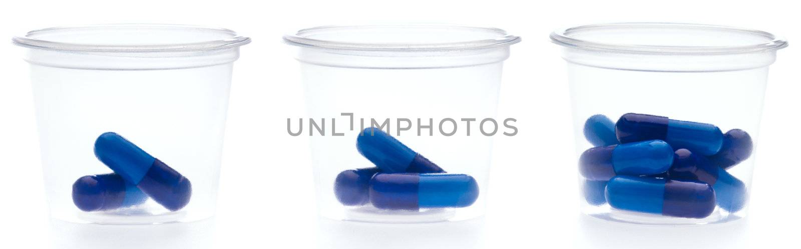 Three containers with different amount of pills, over white
