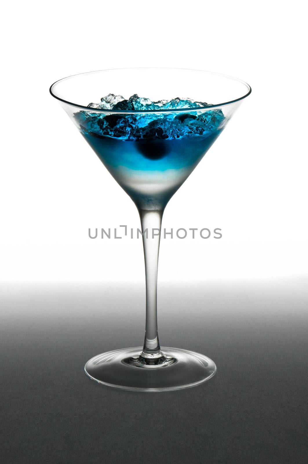 Blueberry cocktail in a martini glass, over white