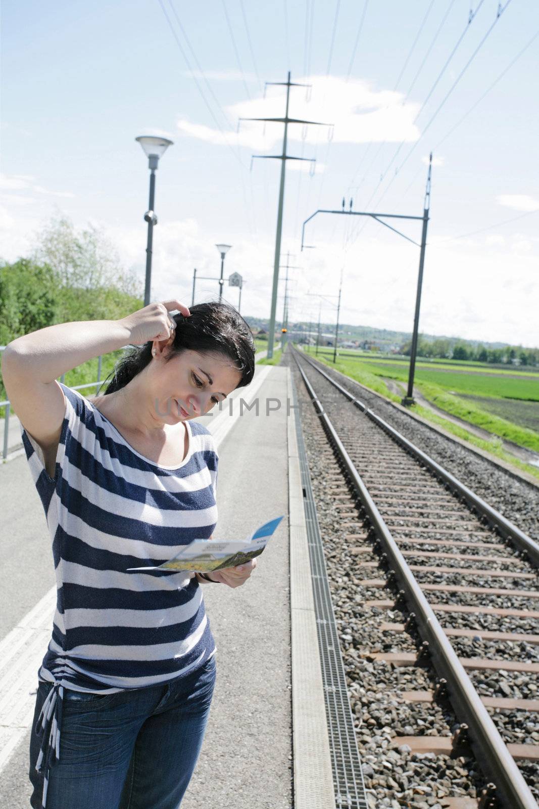 Young woman confused on which direction to choose in a empty railroad