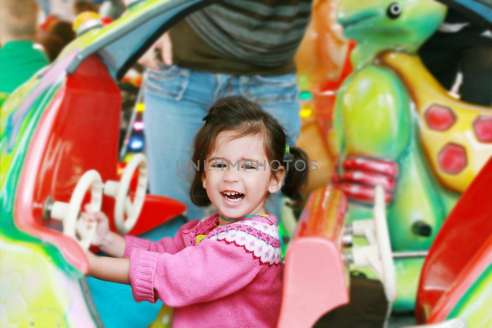 little girl playing on carousel