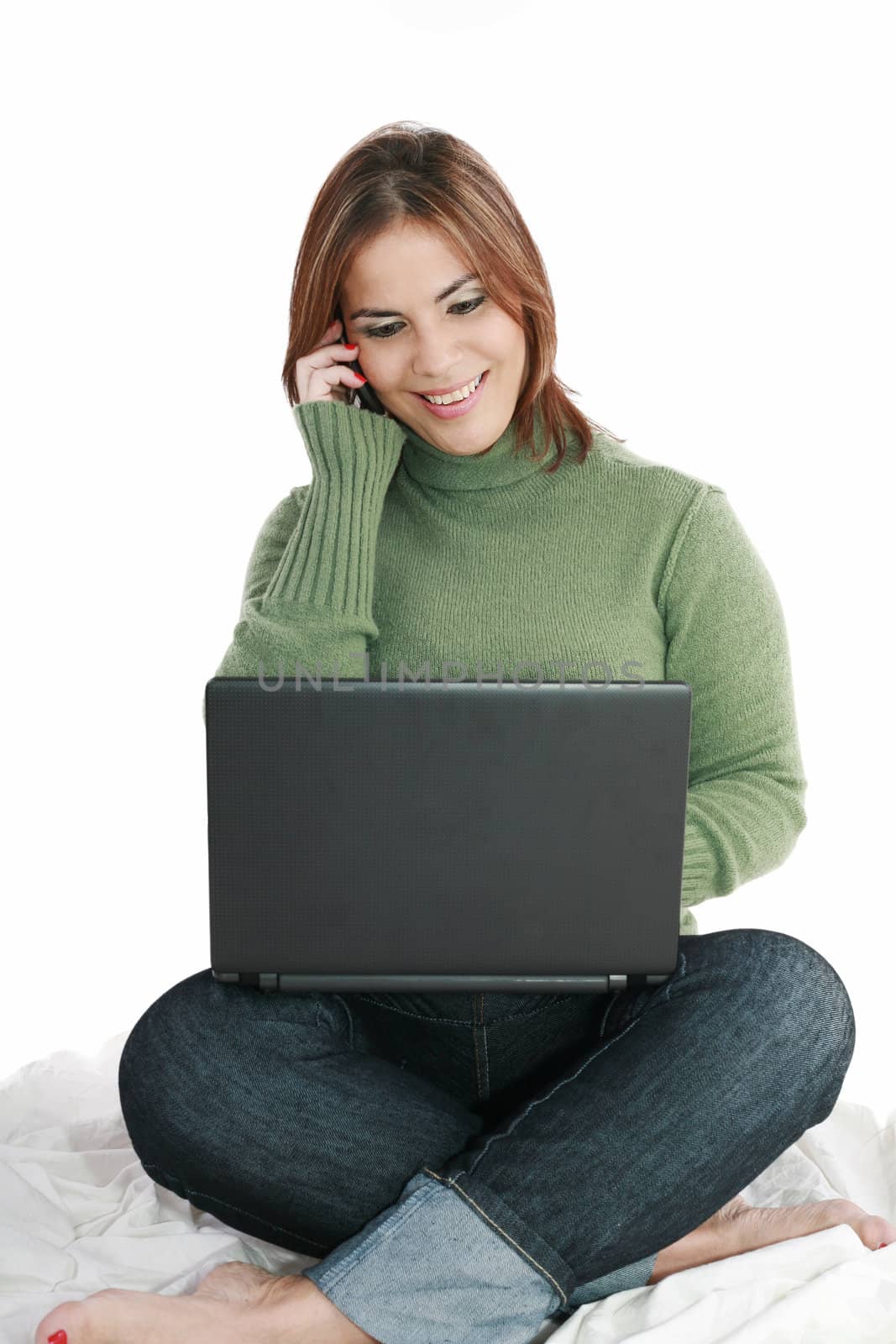 woman talking on mobile phone in front of laptop by dacasdo