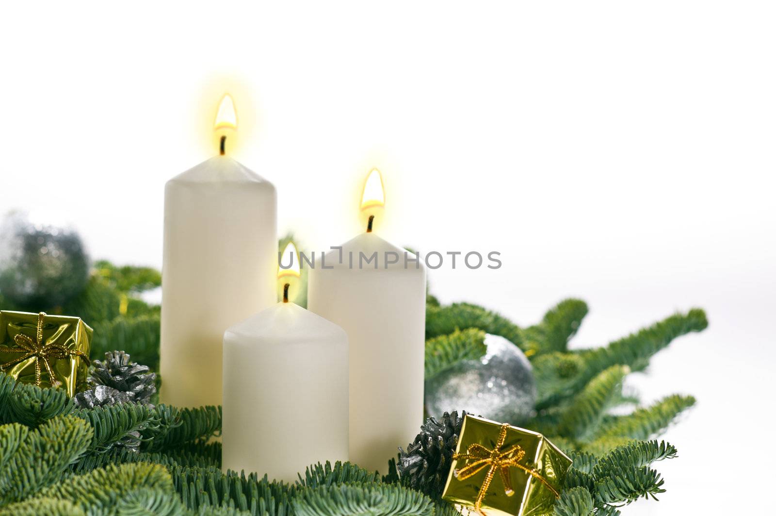 Three candles in advent setting with real Christmas tree branches